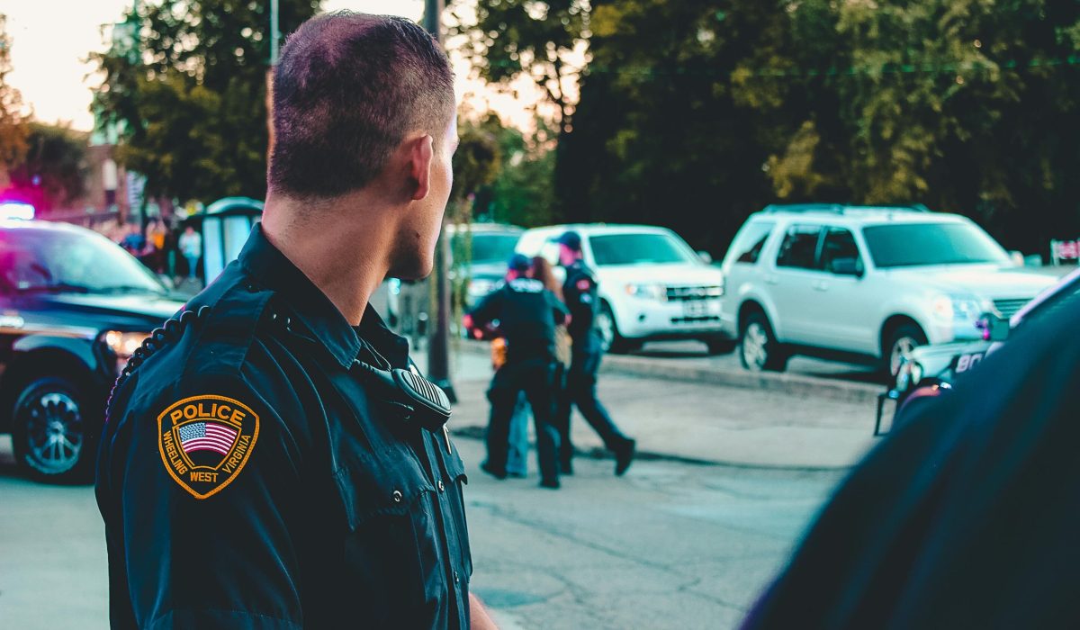 Police officer monitoring a street scene with patrol vehicles in Wheeling, WV.